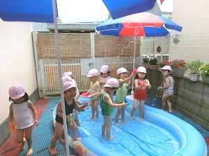 赤ちゃんの家保育園の敷地内でプールに入っている写真