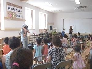 保育園の教室で先生に習い園児たちがダンスをしている写真